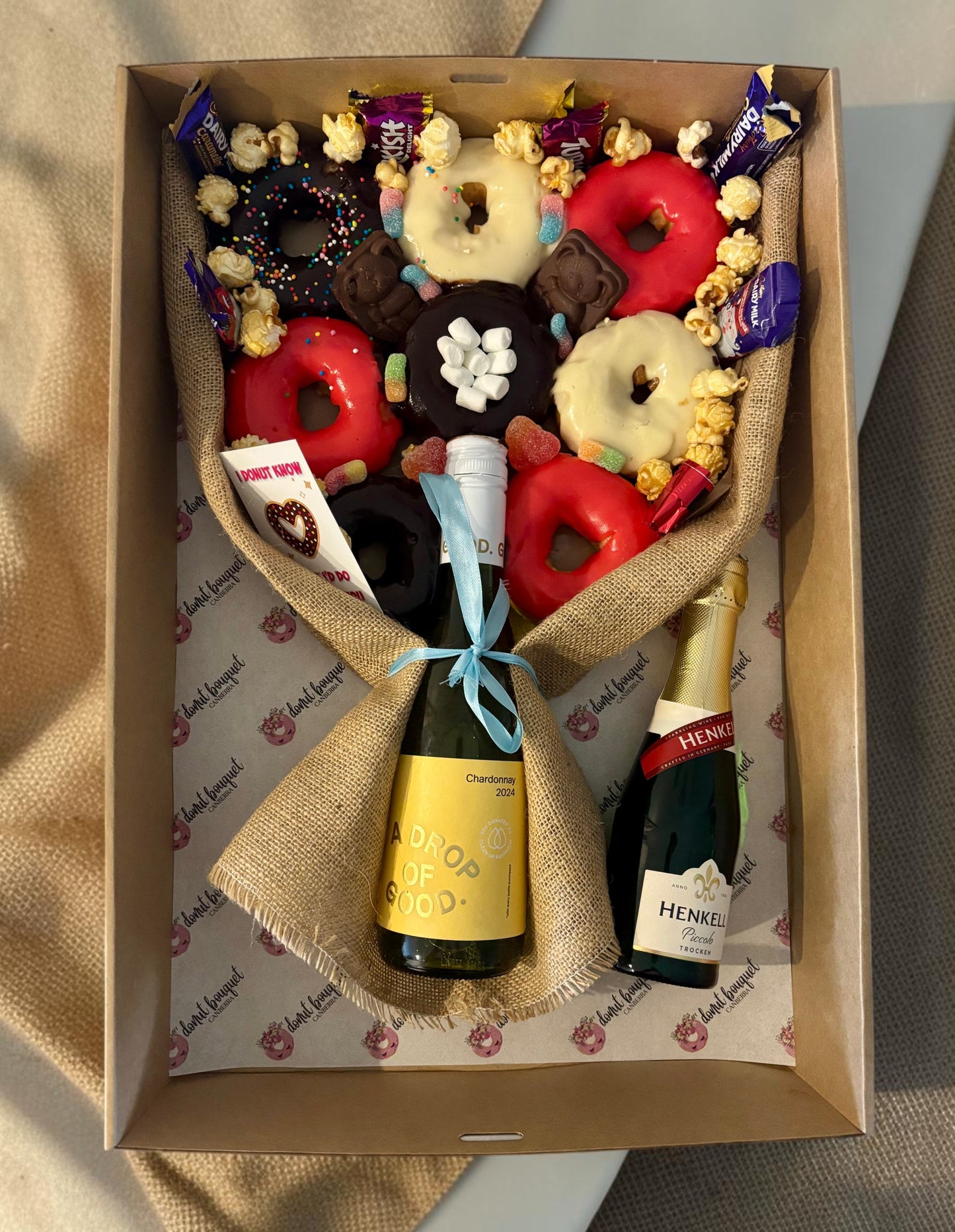 Donut Bouquet Canberra gluten free donut bouquet gift hamper with assorted donuts, chocolates, and a bottle of wine.