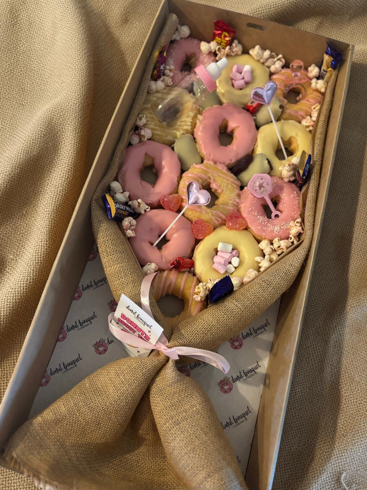 Donut Bouquet Canberra large baby girl gift box featuring pink and yellow glazed donuts with lollies and decorations
