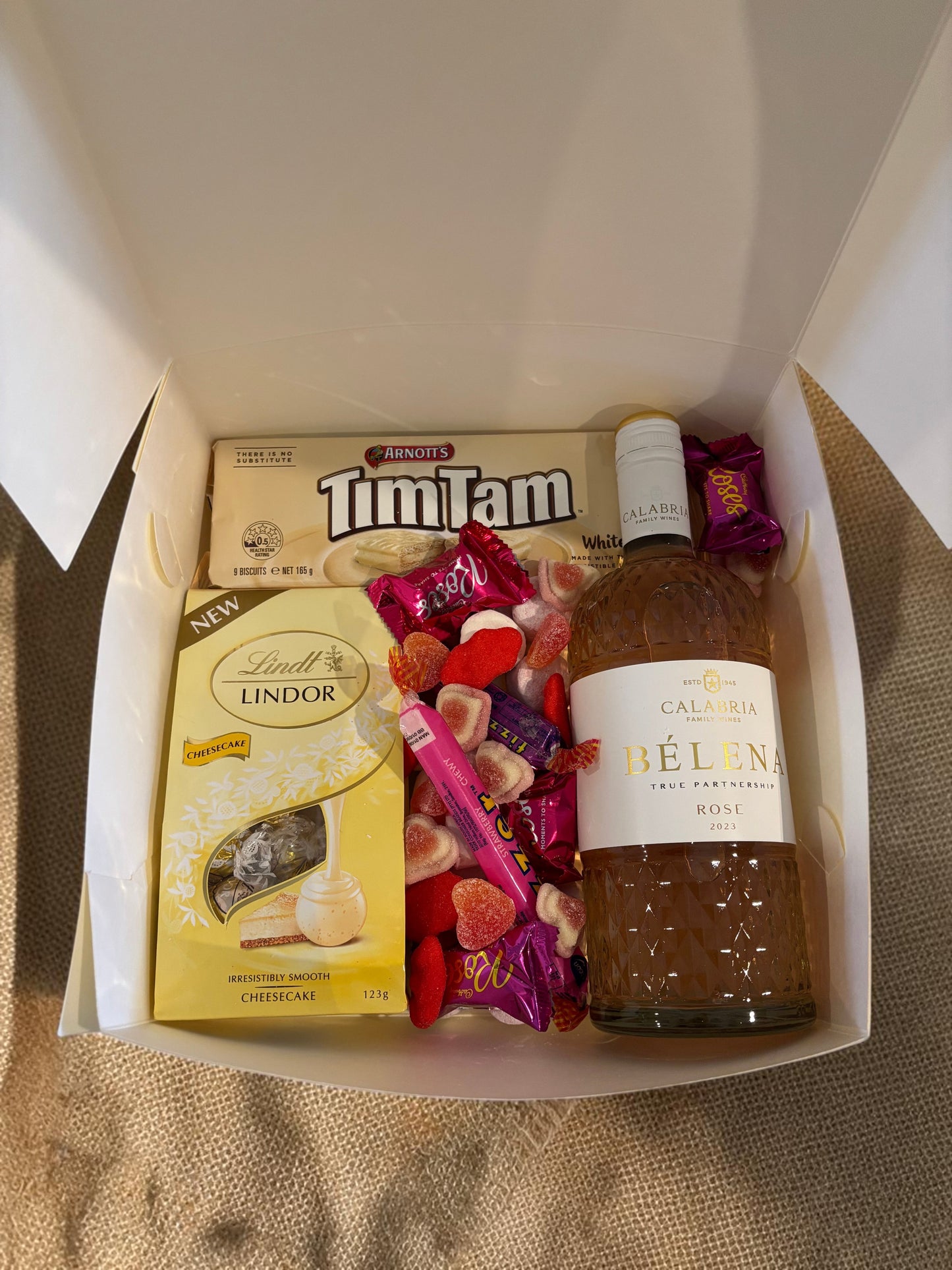 Donut Bouquet Canberra Blushing Rose Hamper with Calabria Rosé, Lindt chocolates, white Tim Tams, and pink lollies.