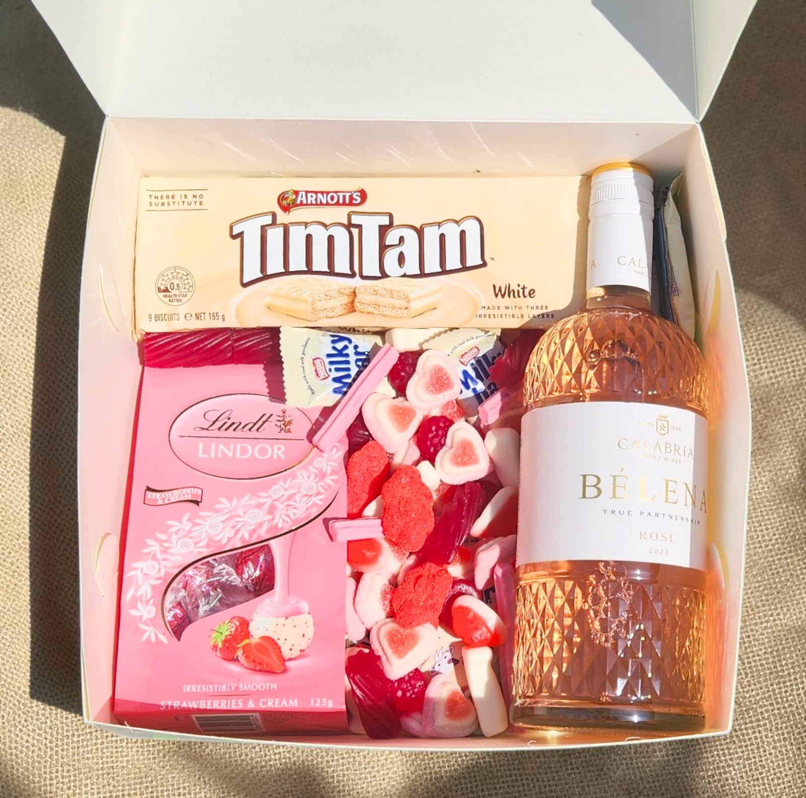 Donut Bouquet Canberra Blushing Rose Hamper with Calabria Rosé, Lindt chocolates, white Tim Tams, and pink lollies.