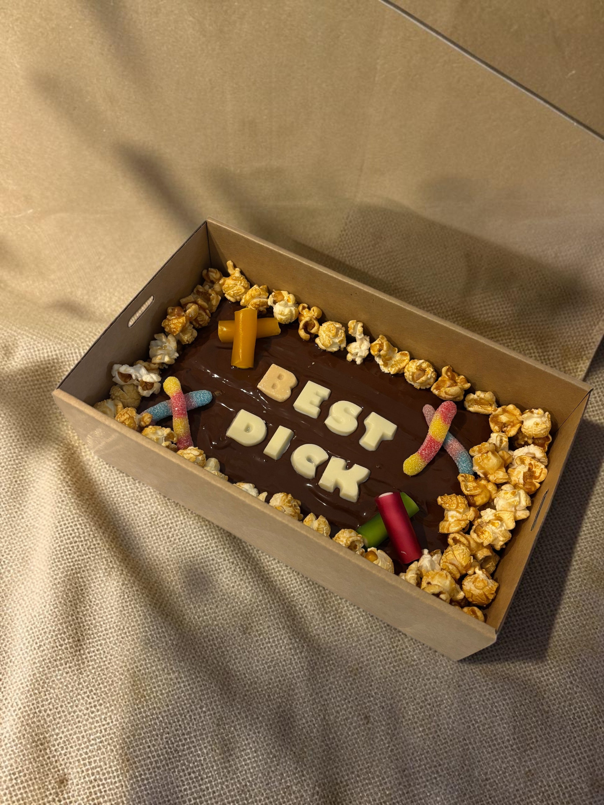 Donut Bouquet Canberra R18+ custom message brownie block topped with white chocolate letters, popcorn, and lollies.
