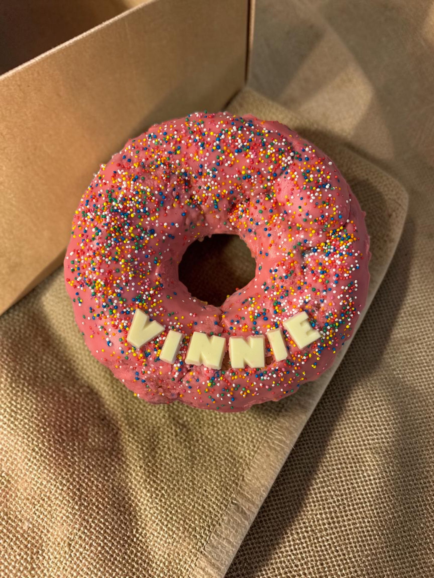 Donut Bouquet Canberra donut cake with bright pink icing and matching sprinkles in a branded white gift box
