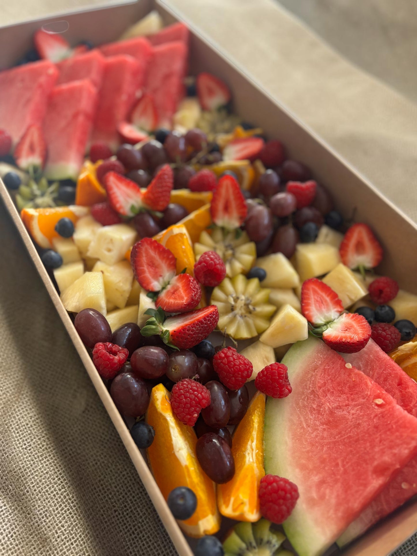 Donut Bouquet Canberra fruit grazing box filled with fresh watermelon, strawberries, grapes, raspberries, and oranges.