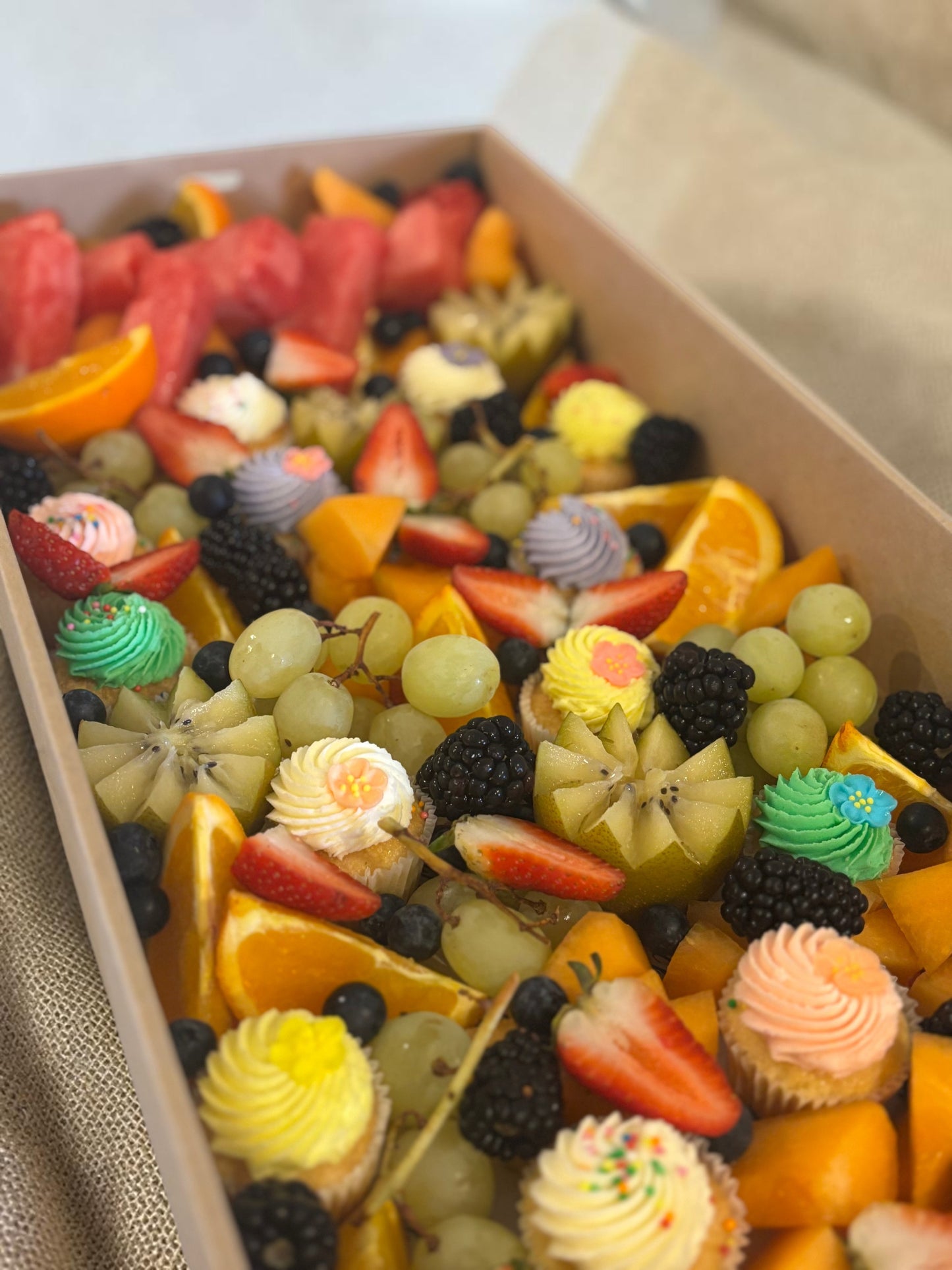 Donut Bouquet Canberra fruit grazing box filled with fresh seasonal berries, melon, kiwi, oranges, and mini cupcakes.