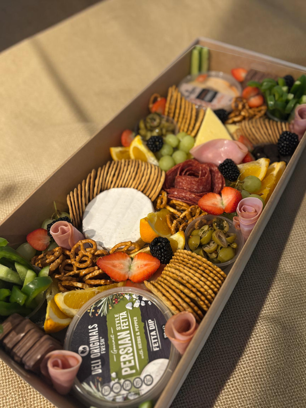 Donut Bouquet Canberra grazing box featuring assorted cheeses, sliced meats, fresh fruit, crackers, and dips.