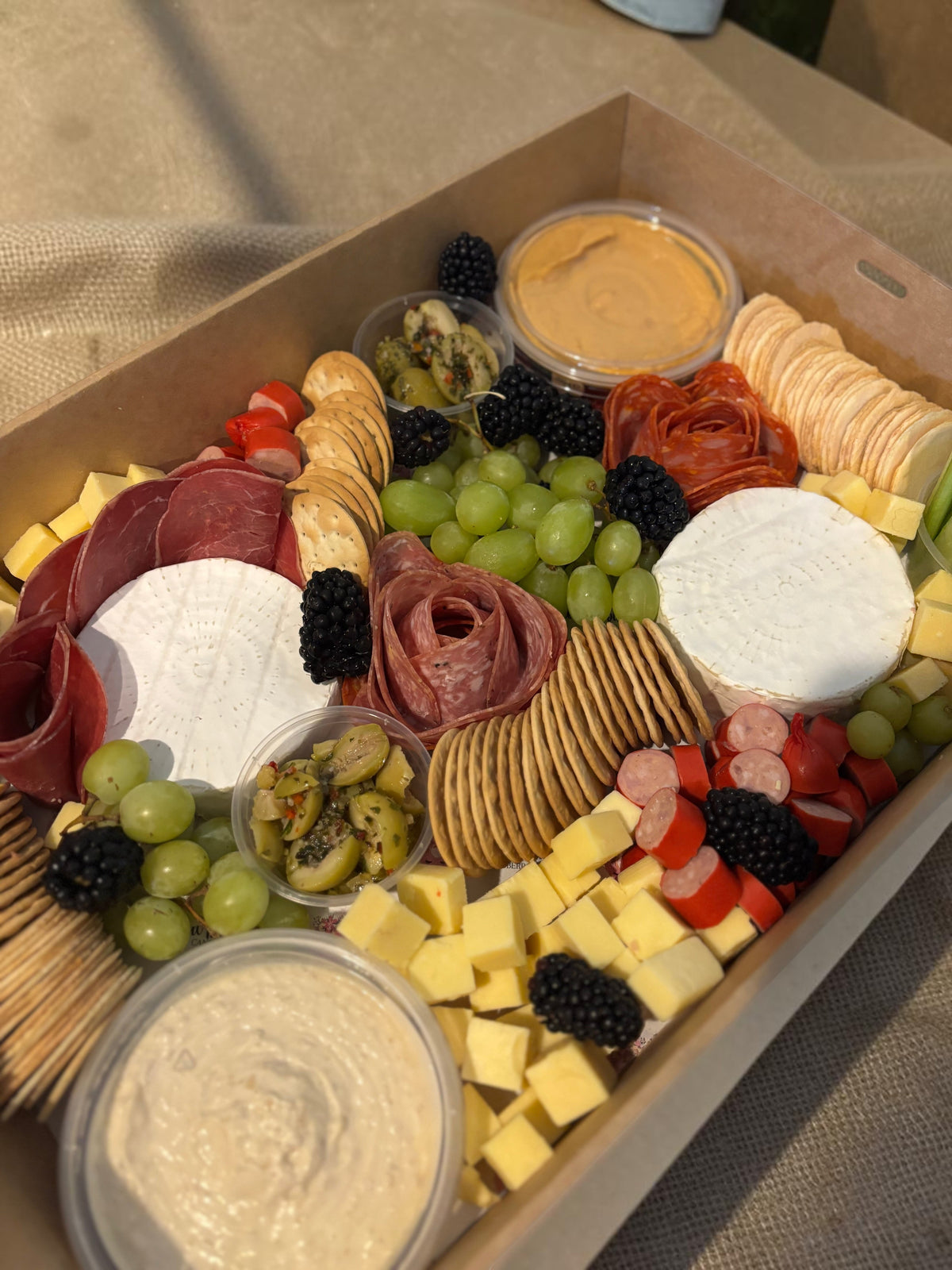 Donut Bouquet Canberra grazing box filled with assorted cheeses, sliced meats, crackers, grapes, and fresh berries.