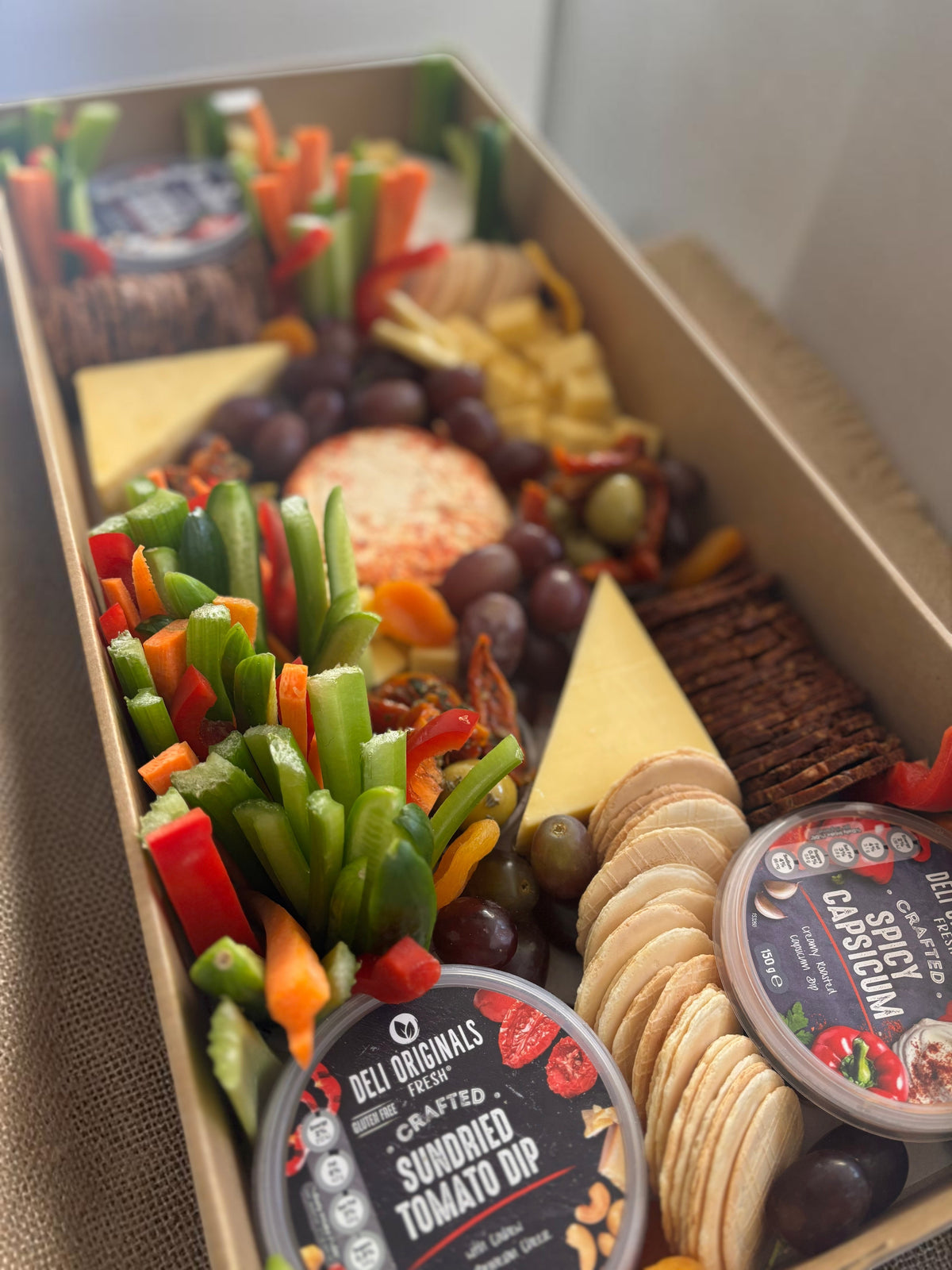 Donut Bouquet Canberra grazing box featuring assorted cheeses, sliced meats, fresh veggie sticks, crackers, and dips.