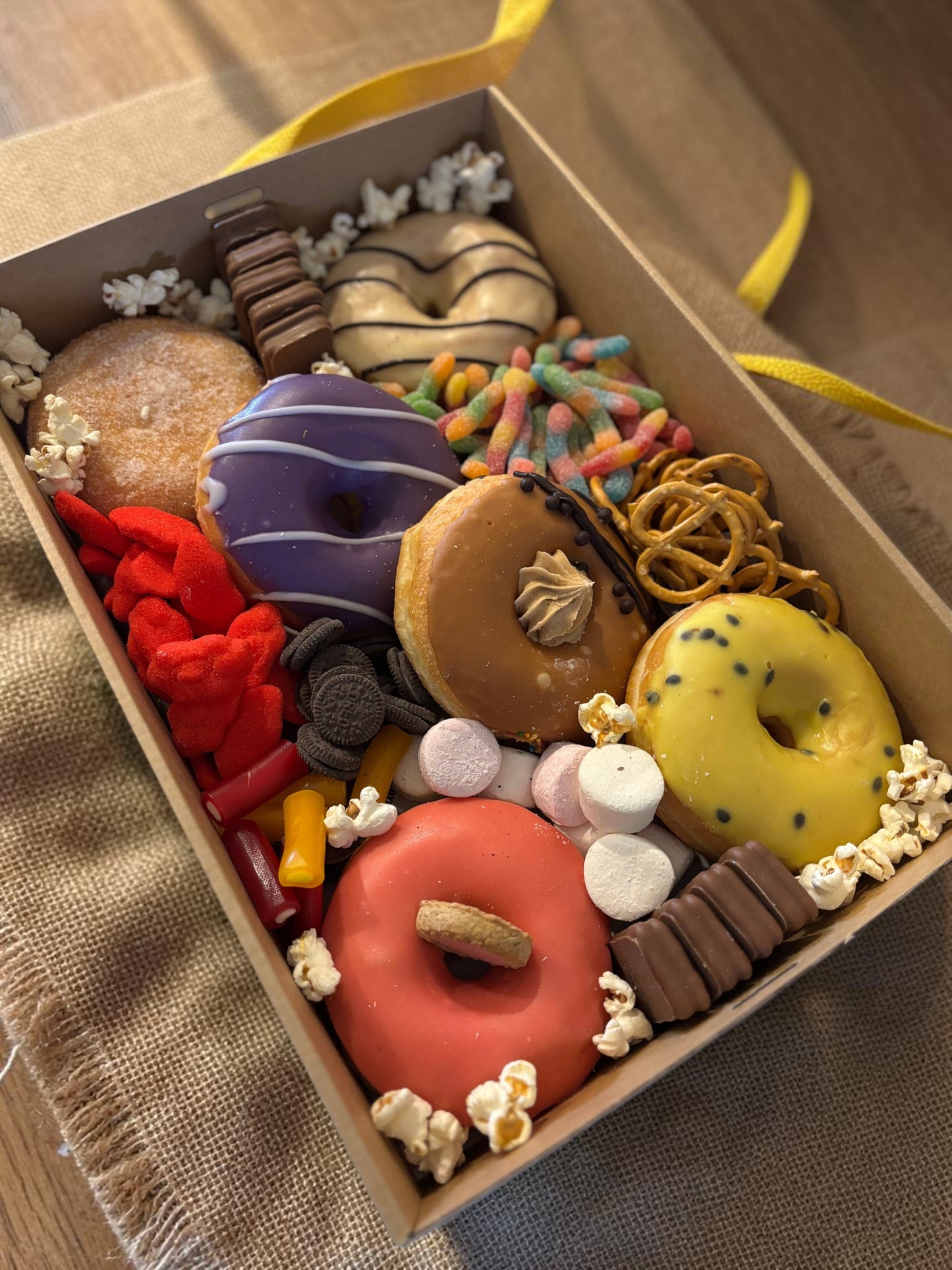 Donut Bouquet Canberra sweets grazing box filled with assorted donuts, pretzels, Oreos, Tim Tams, and colorful lollies.