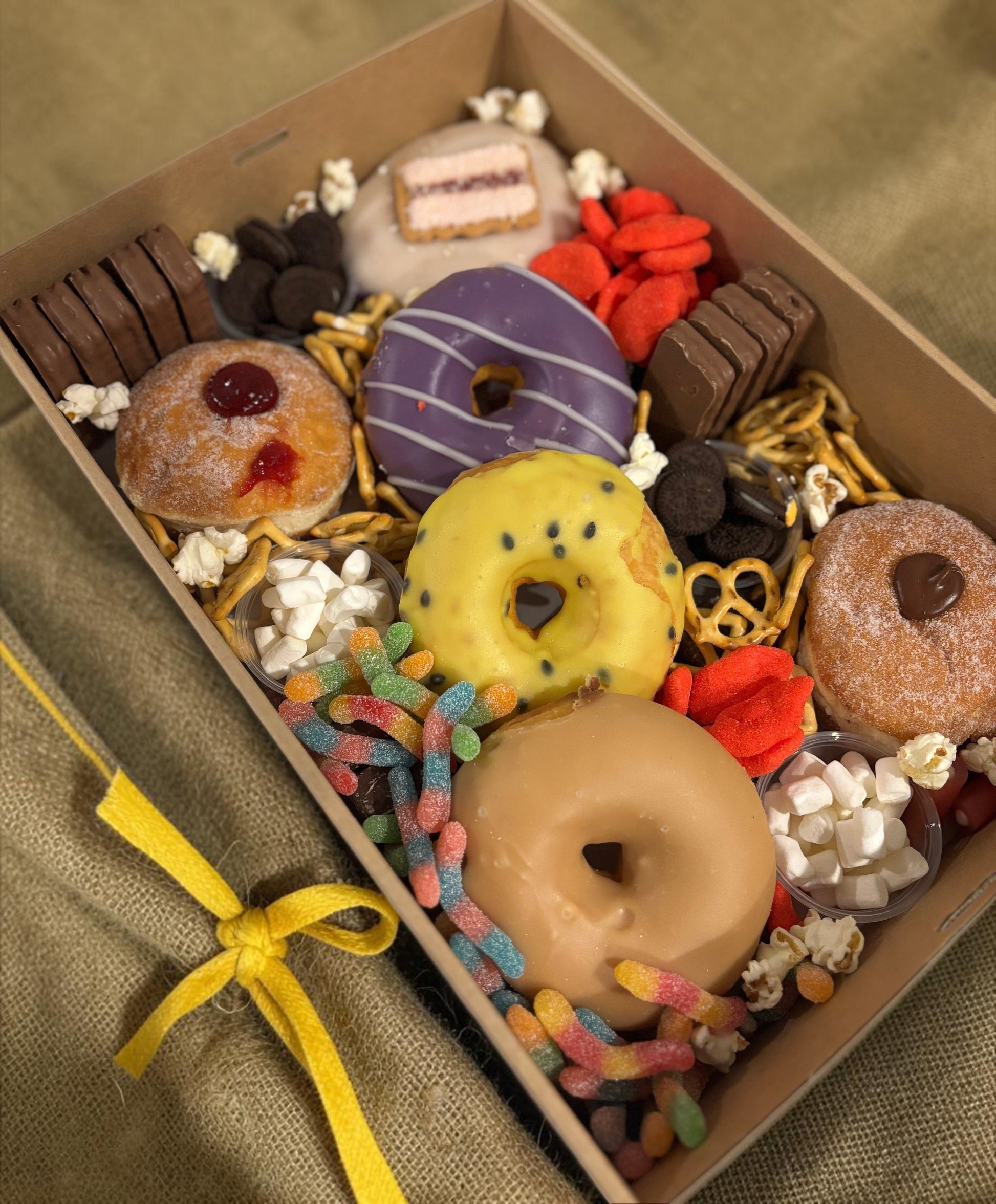 Donut Bouquet Canberra sweets grazing box filled with assorted donuts, pretzels, lollies, and chocolate treats.