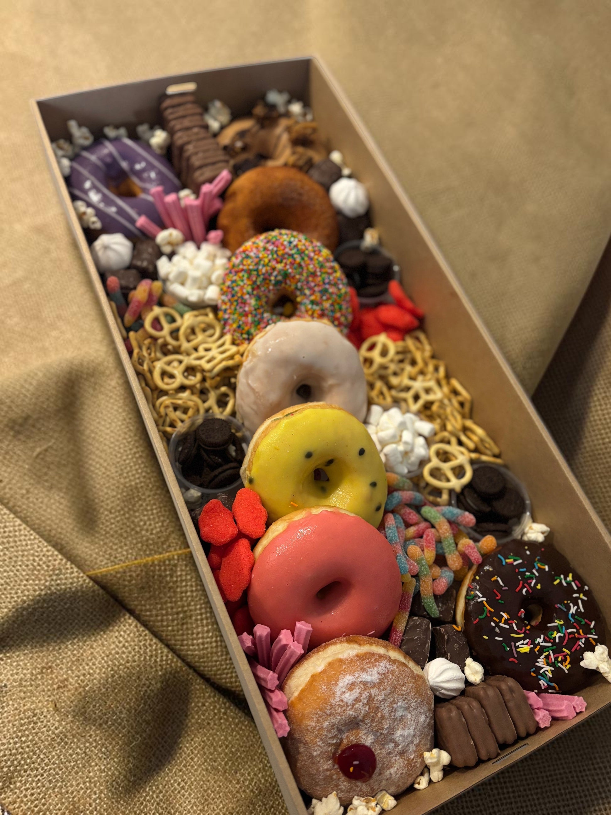 Donut Bouquet Canberra sweets grazing box filled with assorted donuts, pretzels, lollies, and chocolate treats.
