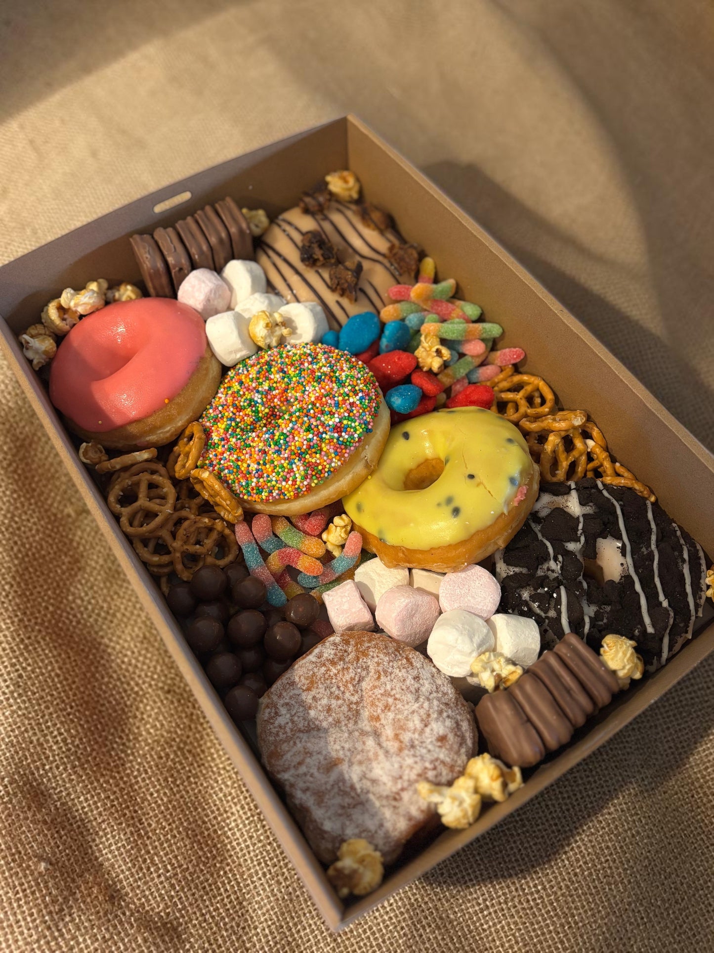 Donut Bouquet Canberra sweets grazing box filled with assorted donuts, pretzels, lollies, and chocolate treats.