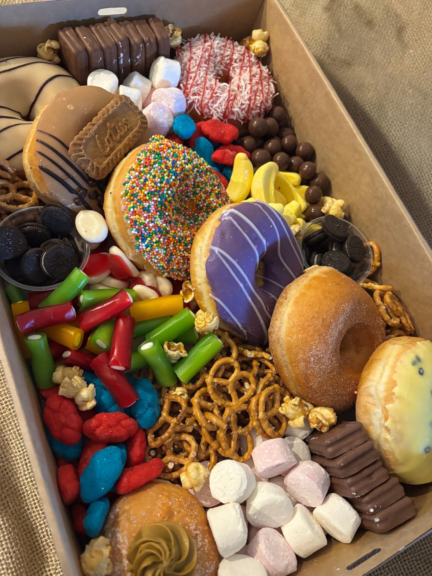 Donut Bouquet Canberra sweets grazing box filled with assorted donuts, pretzels, lollies, and chocolate treats.