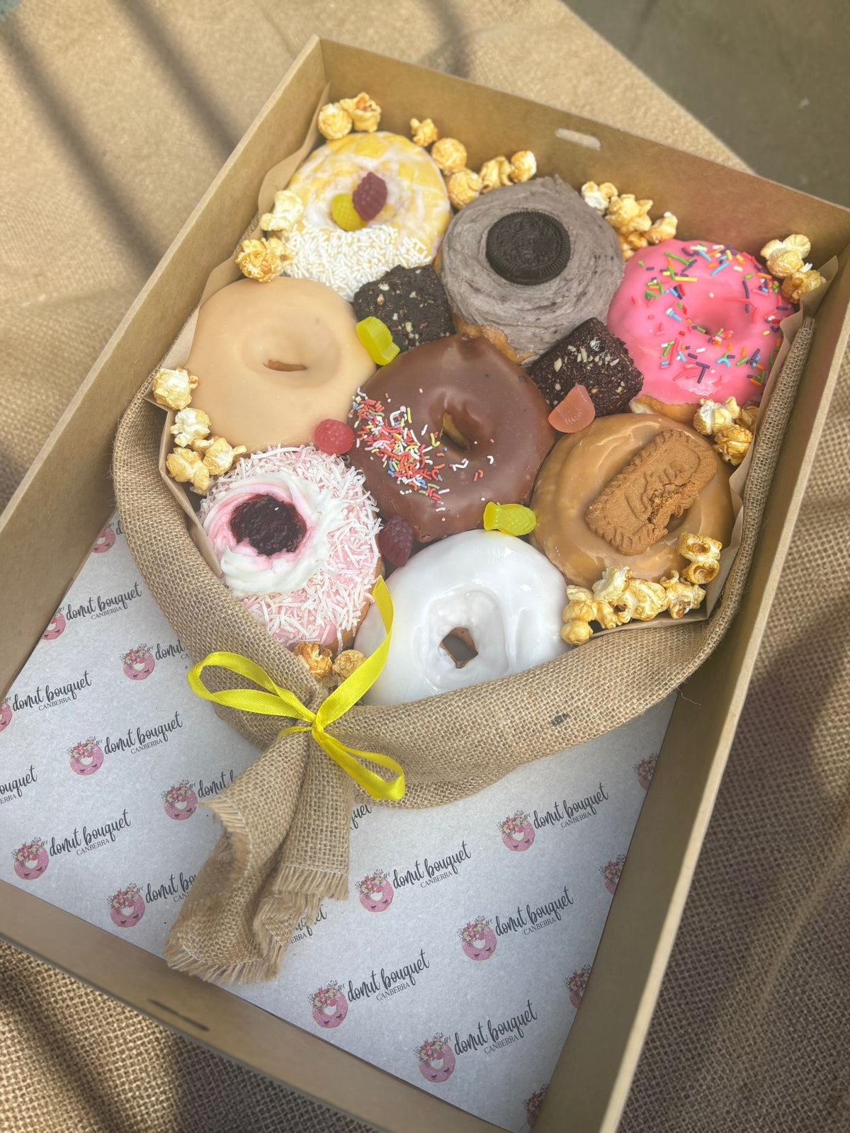 Donut Bouquet Canberra vegan donut gift box featuring assorted glazed donuts, brownies, popcorn, and lollies in hessian