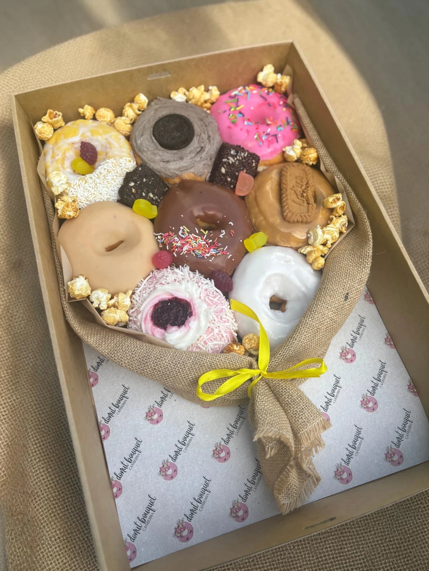 Donut Bouquet Canberra vegan donut gift box featuring assorted glazed donuts, brownie pieces, and popcorn in hessian