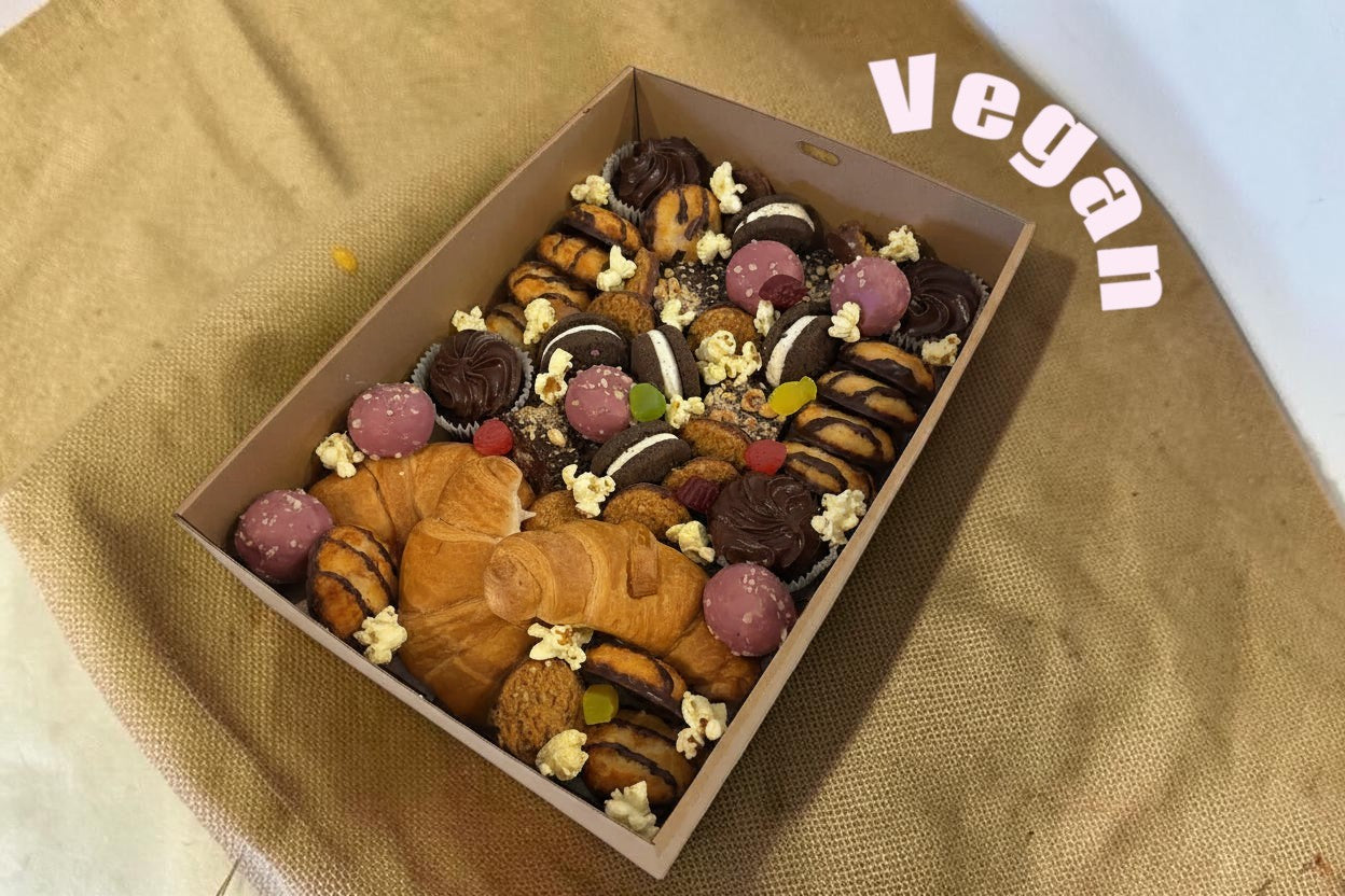 Donut Bouquet Canberra vegan grazing box filled with croissants, chocolate cookies, popcorn, and pink treats.